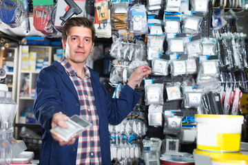 Wall Mural - Smiling seller in hardware store is trading sockets