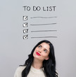 © Tierney - To do list with happy young woman on a gray background