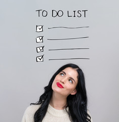 to do list with happy young woman on a gray background