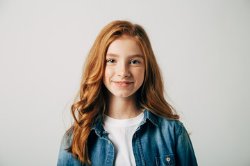 red-haired pretty teenager girl smiling at the camera. isolate on white background. blue-eyed child 