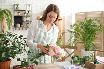 Wall Mural - Female florist making beautiful bouquet in shop