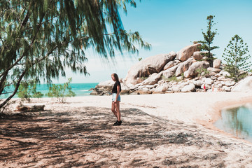 Wall Mural - Young girl resting on the beautiful tropical beach covered in sun light, enjoying life