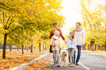 Canvas Print - Happy family with dog walking in autumn park