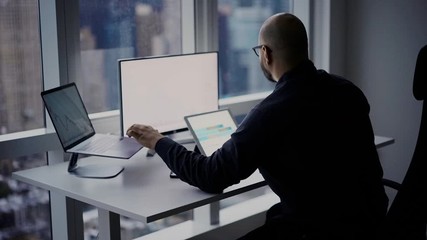 Wall Mural - Male broker in formal wear sitting at desktop table and using digital technology for analyzing web chart of financial investment checking info from infographics, businessman making trade exchange