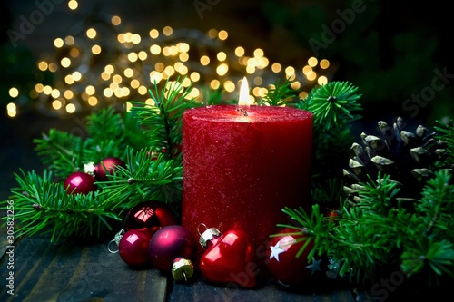 Fotografie, Obraz Brennende rote Adventskerze im Lichterglanz - Weihnachten Dekoration - Erster Ad