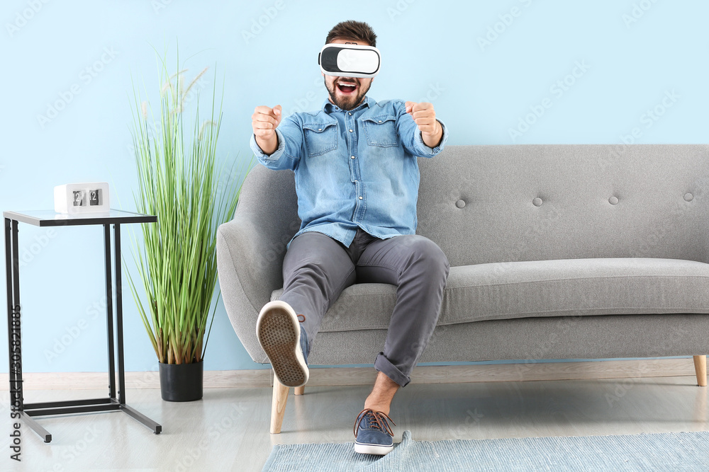 Young man with virtual reality glasses at home