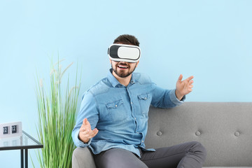 Wall Mural - Young man with virtual reality glasses at home