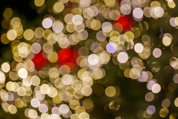 Wall Mural - Gold and red Christmas light shiny abstract round bokeh on black background. Colourful Glitter bokeh from blurry decoration bulbs.