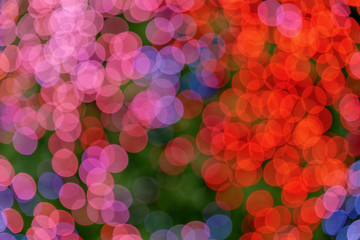 Wall Mural - Red, blue, pink and purple Christmas light shiny abstract round bokeh on dark background. Colourful Glitter bokeh from blurry decoration bulbs.