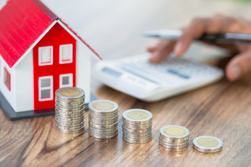 Red roof house model. Coins that are stacked from low to high. Financial and banking concepts Preparing for home purchase and real estate economic growth. Home mortgage finance.