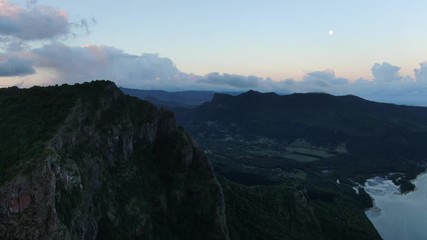 Wall Mural - flying aside of le morne mountain under sunset light with the moon on the sky