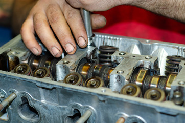 Engineer without gloves repair engine head with tool hand