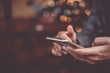 © ant - Woman hand using smartphone in cafe shop background. Business, financial, trade stock maket and social network.