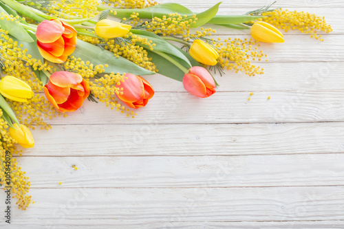 Fotomural tulips and mimosa on white wooden background