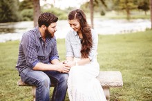 Beautiful Shot Of A Happy Couple Holding Hands While Praying With A Blurred Background
