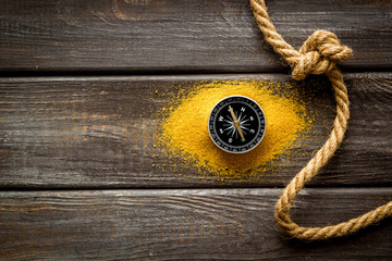 Wall Mural - Goal achievement concept. Compass near rope with knot on dar wooden background top view copy space