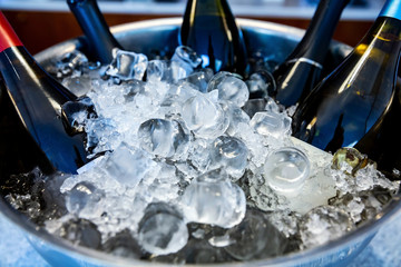 Bottles of wine and champagne, standing in ice bowl on bar counter close up