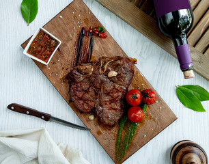 lamb steak served with sauce, grilled tomatoes