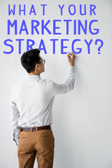 back view of seo manager writing on wall with what your marketing strategy illustration