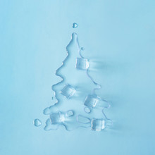 Christmas Tree Shape Made With Melting Ice On Bright Blue Background. Minimal Holiday Concept. Creative Flat Lay.