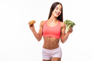 Wall Mural - Young woman holding burger and broccoli on white background. Choice between diet and unhealthy food