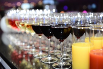 Rows of full champagne, sparkling wine and red wine glasses. Dining, drink. Catering service concept.