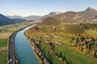 © bilanol - Aerial view of highway interstate road with fast moving traffic near big river in Alps mountains
