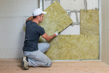 Worker Insulating A Room Wall With Mineral Rock Wool Thermal Insulation.