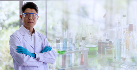 Laboratory concept:  The scientist with a white coat on blurred background of glassware in a chemical laboratory