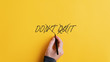 © Gajus - Male hand crossing off a Don't quit sign to change it into a Do it message
