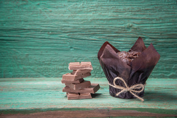 Fresh baked muffins and chocolate slices on a wooden green table for the holiday