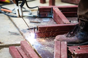 Man Worker welding metal at construction site