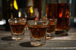 © Atlas - Whiskey shots on wooden table, close up