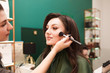© Andrii  - Makeup artist does makeup for a beautiful girl. Woman does face contouring for her client