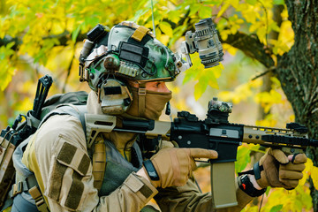 Wall Mural - Closeup airsoft man in uniform, move with machine gun. Soldier aims at the sight. Side view