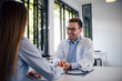 © bnenin - Smiling doctor reassuring his female patient, portrait.
