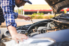 Auto Mechanic Checking The Oil Level In Car Engine,Hand Of Car Mechanic Check Engine Oil For Maintenance.