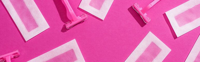 Wall Mural - top view of disposable razors and wax depilation stripes on pink background, panoramic shot