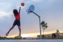 Boy Throwing A Ball In A Basket On A Basketball Court