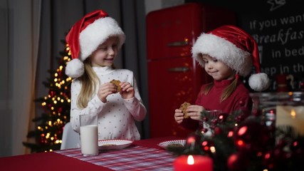 Poster - Cute little children with milk and cookies at table in dining room. Christmas time