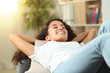 © Antonioguillem - Happy woman resting lying on a couch at home
