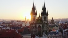 Aerial Shot Church Of Our Lady And Old Town District In Prague At Sunrise. Camera Moving Laterally Flying Laterally Against Facade Famous Cathedral In Sun Shining. Picturesque Cityscape At Morning