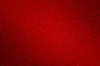 Wet with water drops dark red background with gradient illumination at two corners, closeup, details