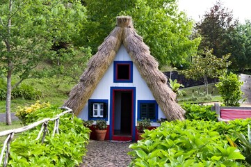 Wall Mural - Typical old house of Santana in Madeira Island with a particular thatched roof and a red and white facade (Santana, Madeira, Portugal)