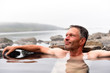 Man bathing and relaxing in hot springs during summer day. Natural hot geothermal springs and pool in the Iceland, Europe.