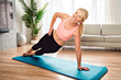 © Louis-Photo - Portrait of fit woman training in her living room on an exercise mat