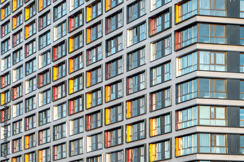 Muticolor facade of a residential multi-storey building with large windows. Modern architecture. Real estate in a big city. Background from the wall of the house. - obrazy, fototapety, plakaty 