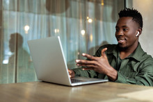 Handsome African American Man Using Computer And Smiling. Online Video Chat With Business Partners
