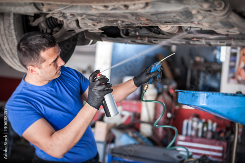 Fotografía Car master mechanic repairer lubricates screws with machine cleaner spray
