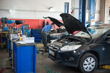 Car mechanic repairer service technician checks and repairs auto engine